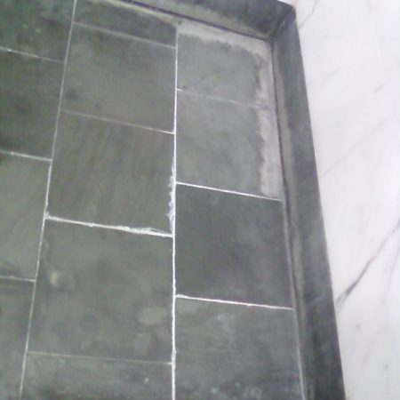 Minerals Efflorescence Buildup on Shower Floor (Before Restoration)