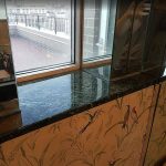 Dark marble bathroom windowsill after transparent polyester resin coating – smooth glossy mirror-like finish