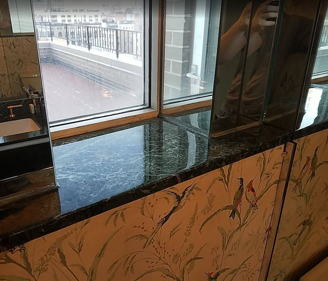 Dark marble bathroom windowsill after transparent polyester resin coating – smooth glossy mirror-like finish