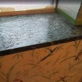 Heavily pitted and weathered dark marble windowsill before polyester resin fill-in coating treatment