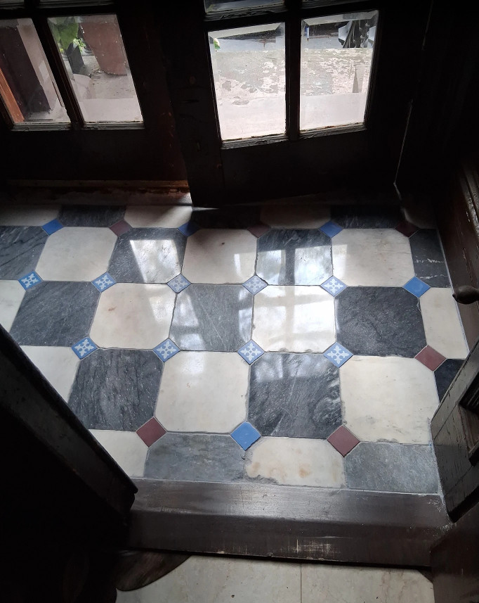 Vestibule floor with octagonal brown stone tiles after professional restoration – polished and gleaming surface