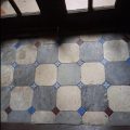 Vestibule floor with octagonal brown stone tiles before professional restoration – dirty and dull surface