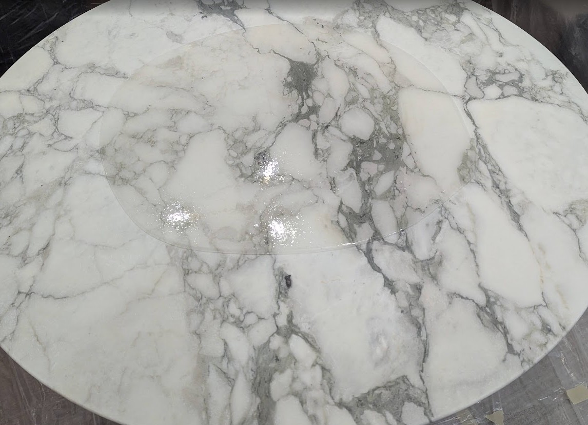 Flowing Transparent Polyester Epoxy Pour Over Table Self-leveling transparent polyester epoxy flowing and spreading over Saarinen marble table surface