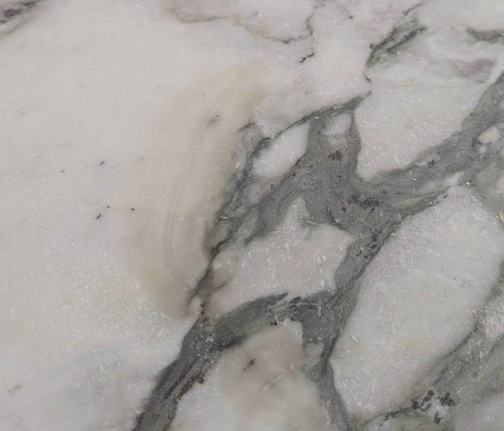 color stain on uncoated spot before reducing Residual color stain on uncoated marble spot requiring reduction before new epoxy application