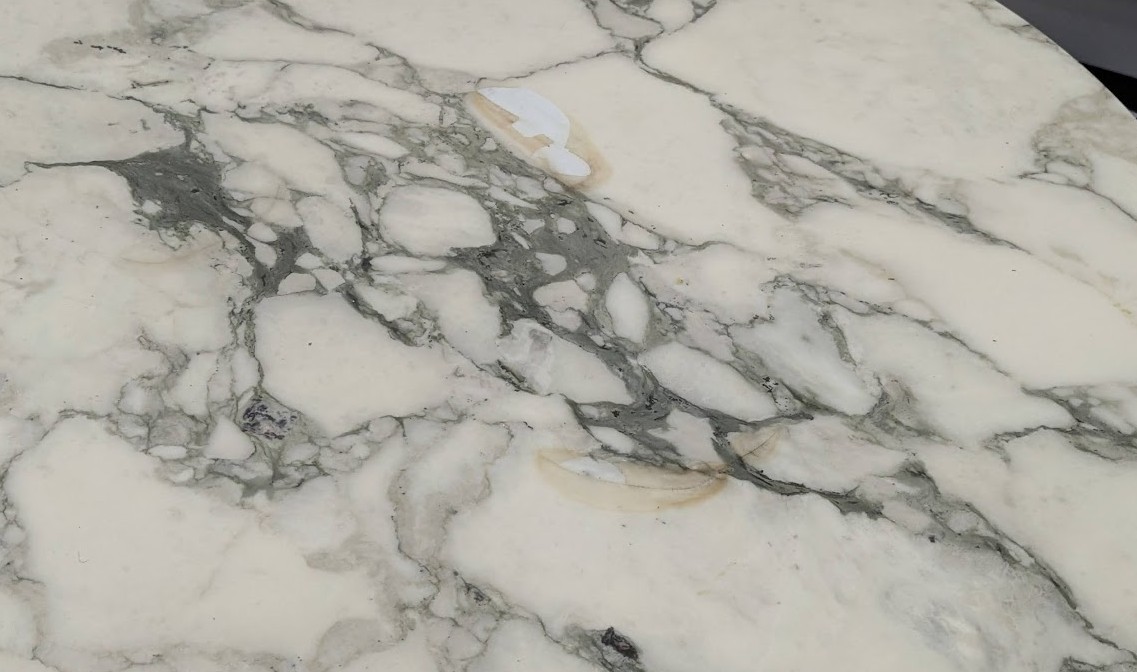 peel offs and stains on table coat Cracked and stained old polyester resin coat on a Knoll Saarinen marble table top before stripping