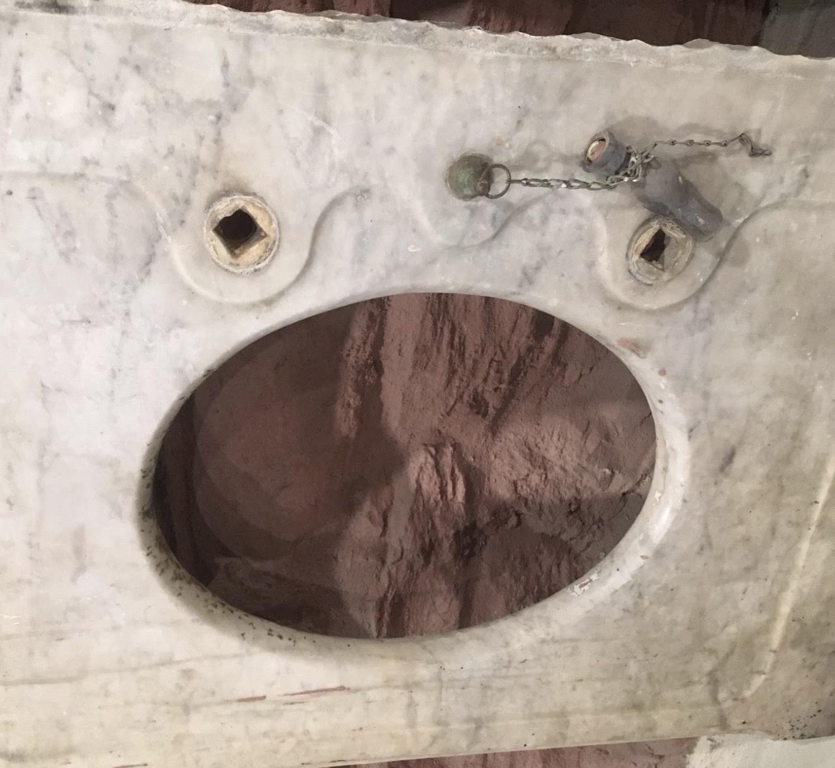 Marble countertop from about 1890 with a square mortise at each faucet hole above an oval basin opening