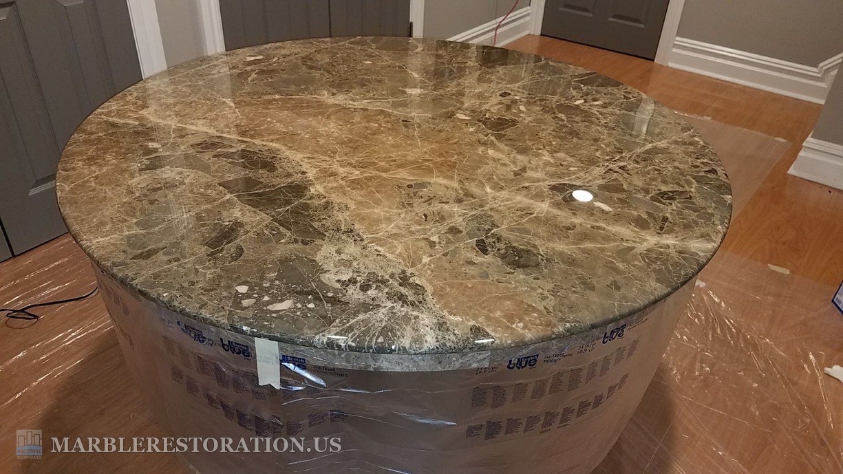 Emperador marble table after re-coating Round Emperador Dark marble table top with a new high-gloss clear coat, the pedestal base wrapped in plastic
