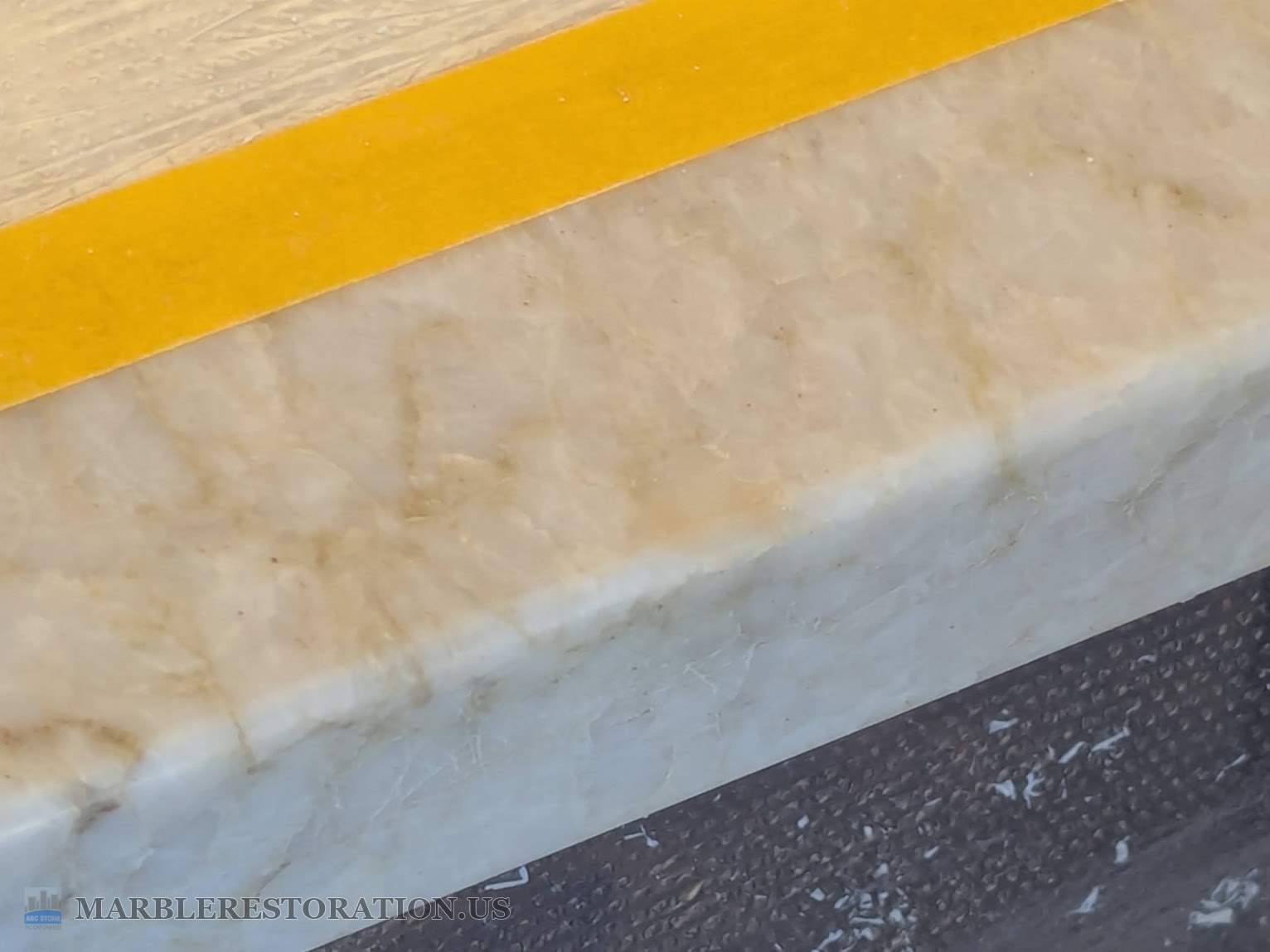 Leathered quartzite countertop edge after the chip was filled with colored epoxy Edge of the leathered quartzite countertop with the chip filled with colored epoxy, yellow tape along the top