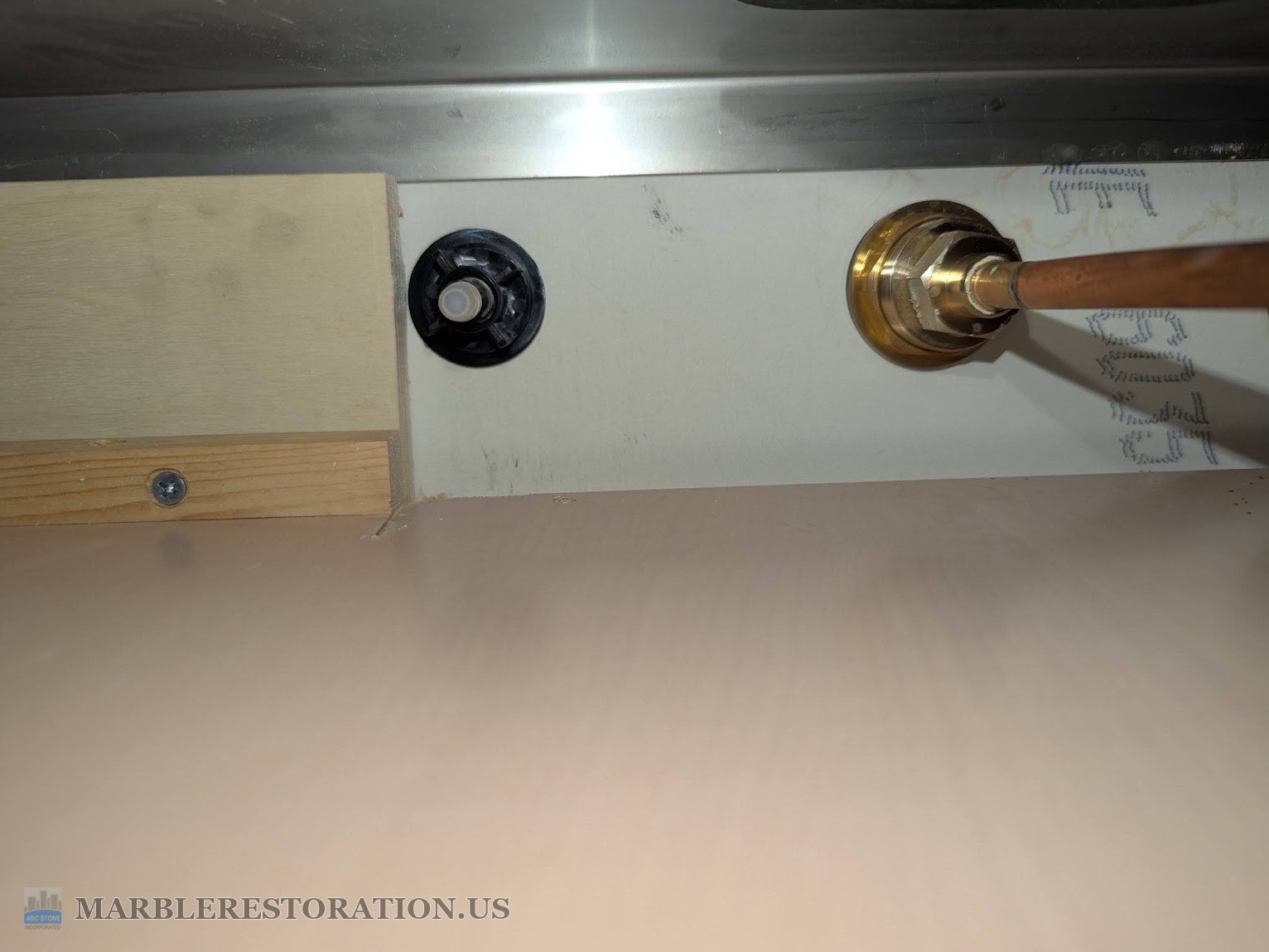 Water filter faucet mounting nut under the quartz countertop The black plastic mounting nut of a water filter faucet tightened under a quartz countertop, next to a brass fitting and copper supply line